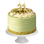 Green birthday cake with gold decorations and number 21 candles on a white background
