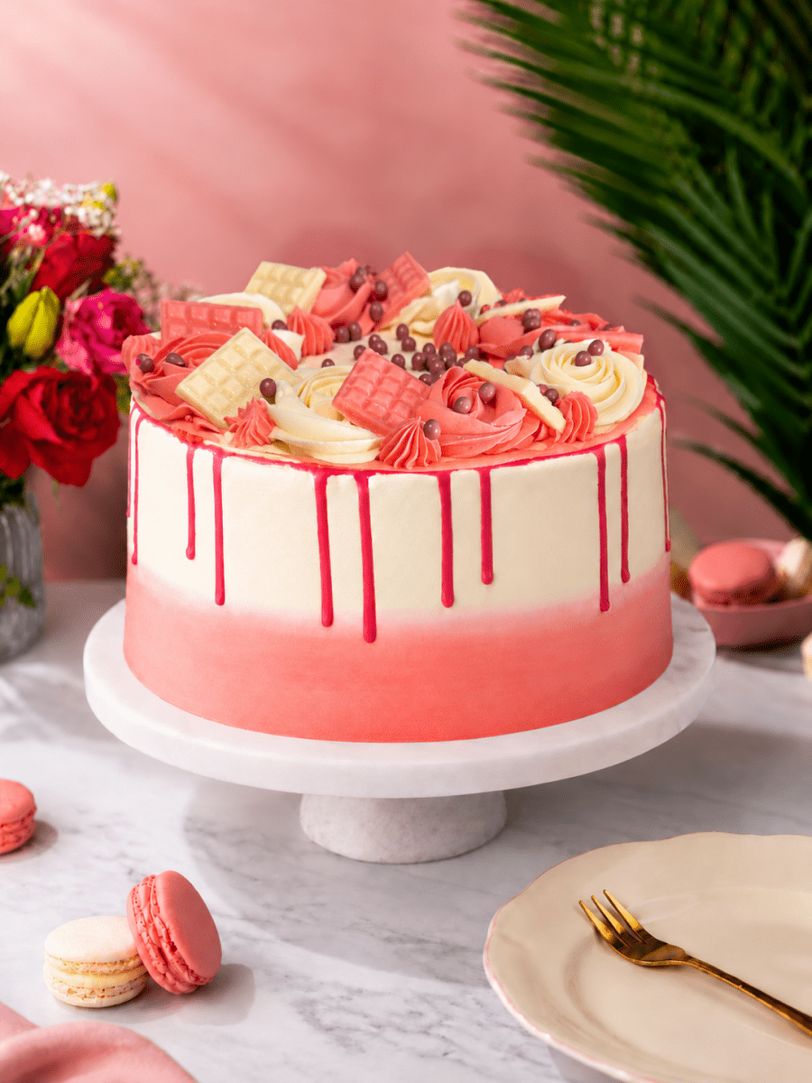 Blush Pink Celebration Drip Cake with pink ombré buttercream, piped swirls and pink and white mini chocolate bars.