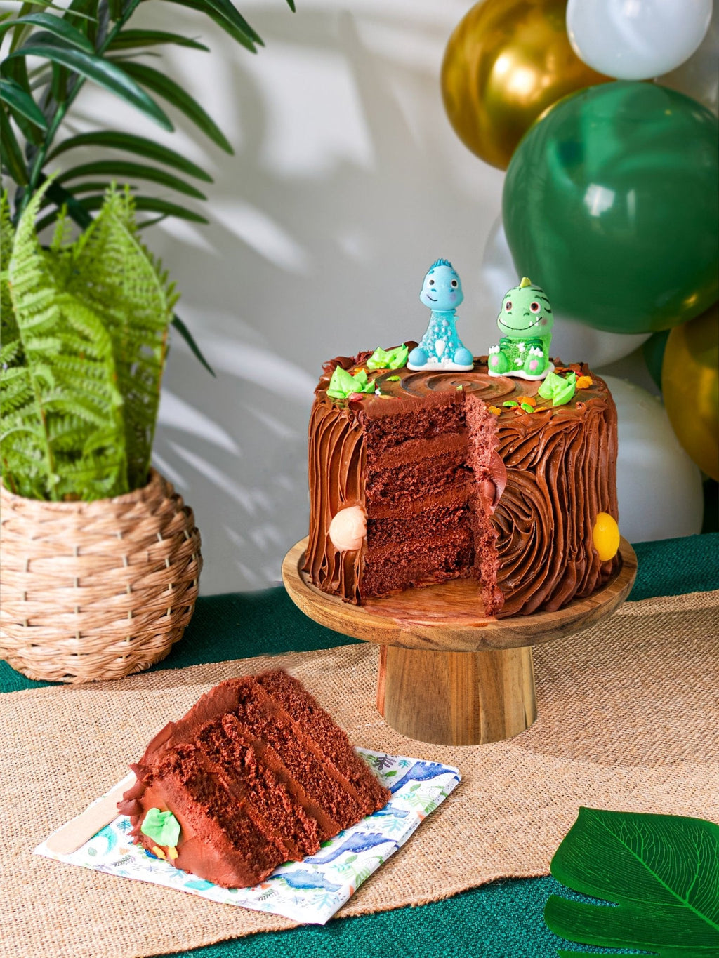 Patisserie Valerie's handmade Chocolate Dinosaur Cake with dinosaur toppers, being sliced and served