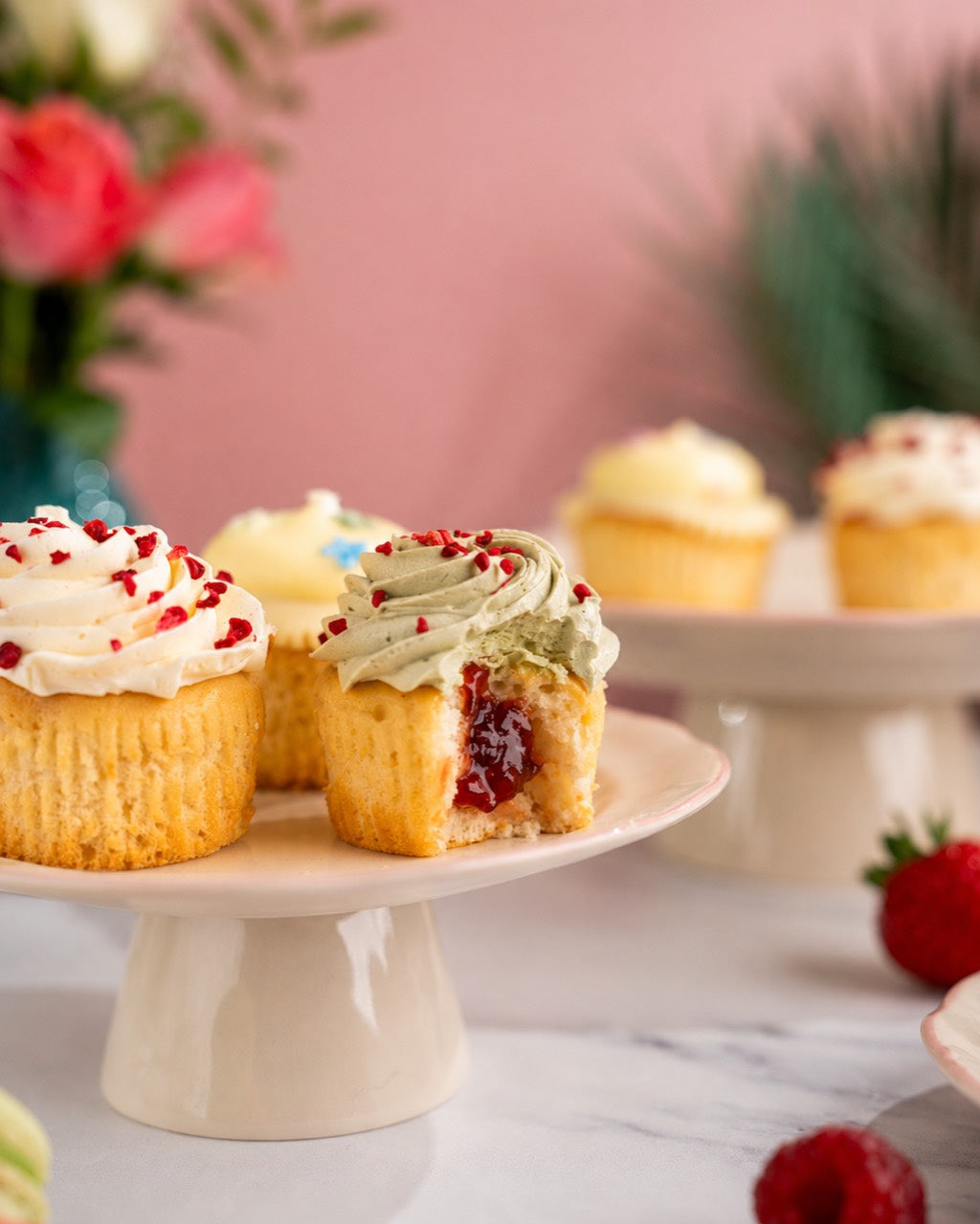 Raspberry and Matcha cupcake cut open to show its raspberry filling
