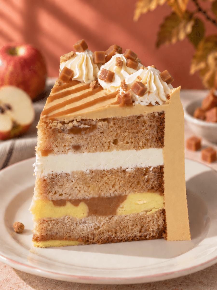 Slice of Toffee Apple Celebration Cake showing the cinnamon apple sponge and cream layers